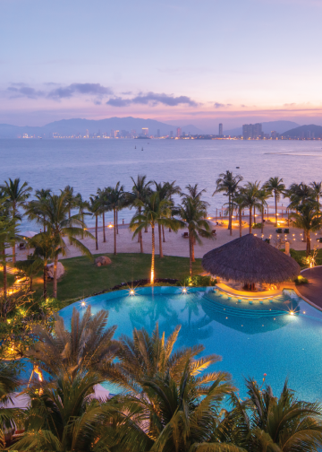 Khung cảnh bao quát của Boma Resort Nha Trang tọa lạc bên bờ biển với triền núi xanh mướt, thể hiện sự hòa quyện giữa thiên nhiên và kiến trúc